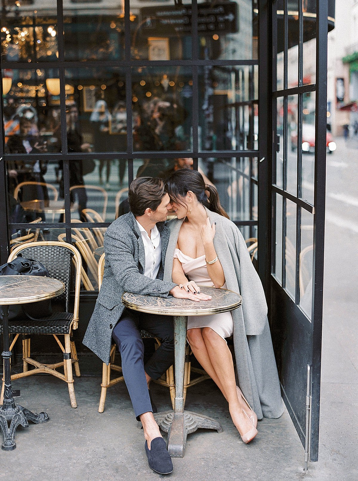 romantic couple at a cafe for their engagement photos in paris
