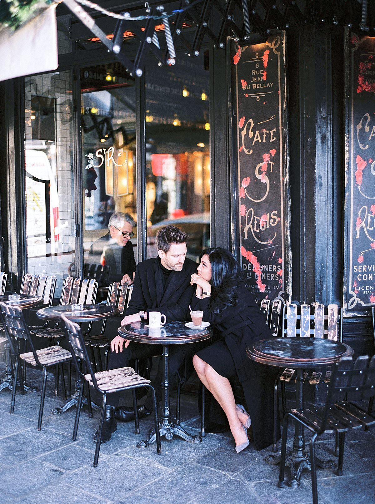 A couple sitting at a cafe in Paris for their pre wedding shoot - Le Secret D'Audrey