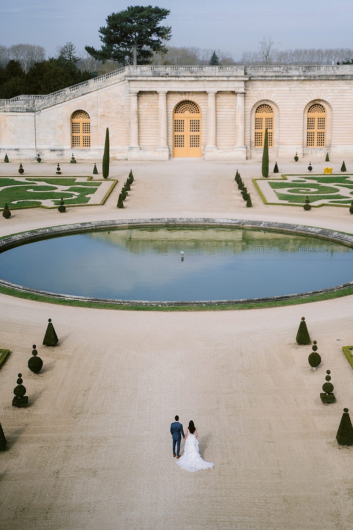 The newly engaged couple walk in the garden of the Chateau de Versailles 